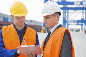 Two ship workers discussing over a clipboard