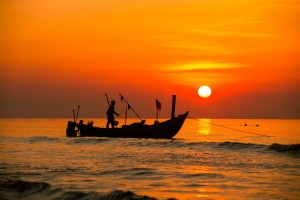 small fishing boat at sea at sunset