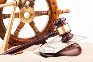 Gavel and ship steering wheel set over Maritime Law paper