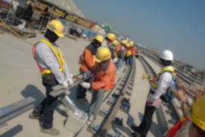Workers install DC voltage conductor rail of sky train