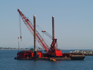 Marine dredge and pile driver sits anchored off of the Taawasan Ferry Terminal near Vancouver, BC. Point Roberts, Washington can be seen in the background