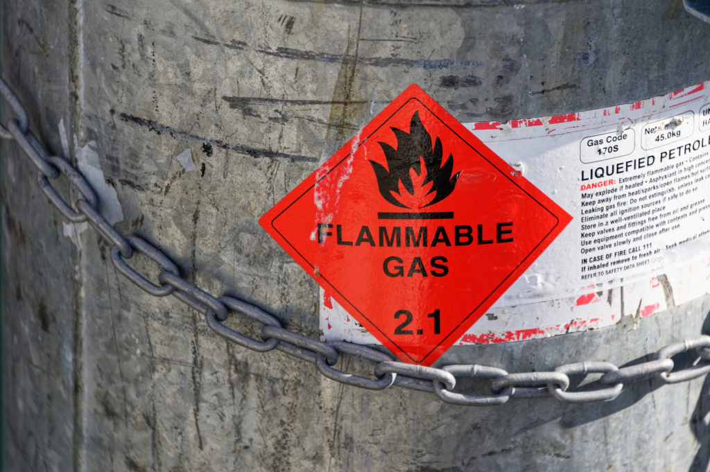 An LPG tank secured with a strong chain and showing a Flammable Gas 2.1 sign