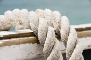Close up of rope on the edge of a boat, with the sea in the background. Shallow depth of field used.